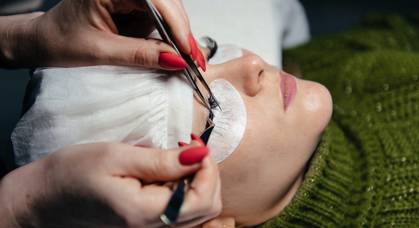 eyelash-extension-process-closeup-portrait-young-girl-woman-with-long-thick-eyelashes-eyes-closed-hand-cosmetologist-adding-more-eyelashes-her eyelash-extension-process-closeup-portrait-young-girl-woman-with-long-thick-eyelashes-eyes-closed-hand-cosmetologist-adding-more-eyelashes-her